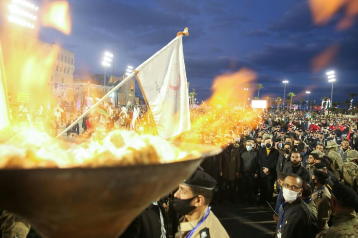 Libyans light a commemorative torch in the capital's Martyrs' Square as celebrations get under way for the 10th anniversary of the launch of the uprising that toppled longtime dictator Moamer Kadhafi