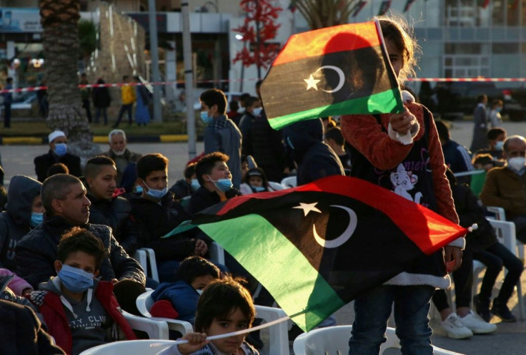 Libyan children wave national flags at an anniversary military parade in the Mediterranean port city of Tajura