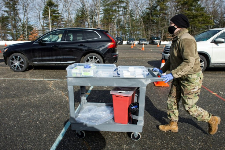 A US National Guard soldier pushes a cart with syringes loaded with the Moderna Covid-19 vaccine at a vaccination center in Londonderry, New Hampshire