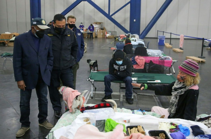Houston Mayor Sylvester Turner (L) and Harris County Sherriff Ed Gonzales (2nd L) take a tour of the George R. Brown Center which is being used as a warming shelter on February 17, 2021 in Houston, Texas. A winter storm has caused rolling black-outs throu