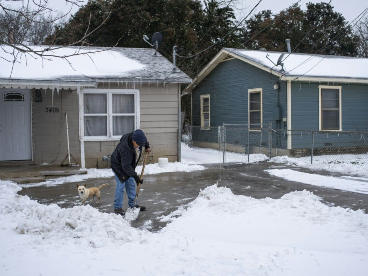 A resident in Waco, Texas clears snow as the oil-rich state struggles to cope with a historic cold snap