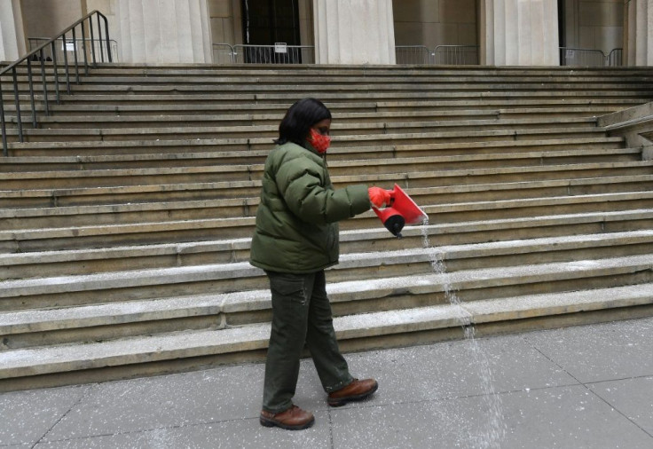A worker distributes salt in preparation for a snow storm at Wall Street in New York
