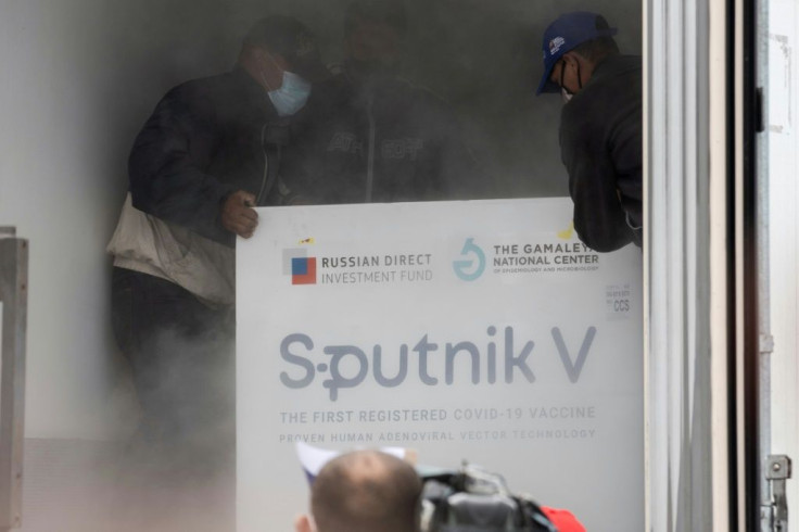 Venezuelan airport workers place packages containing 100,000 doses of the Russian Sputnik V vaccine against Covid-19 in a refrigerated truck at the Simon Bolivar international airport in La Guaira, Venezuela on February 13, 2021