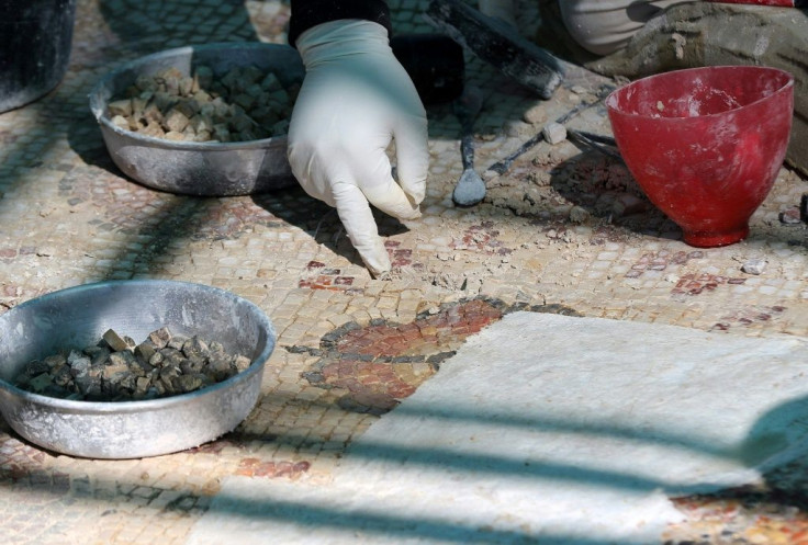 A worker restores a mosaic floor at an ancient church in the small Jordanian town of Rihab