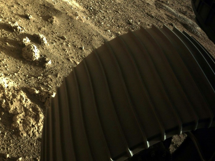 A second color image shows one of the rover's six wheels, with several honeycombed rocks thought to be more than 3.6 billion years old Â lying next to it