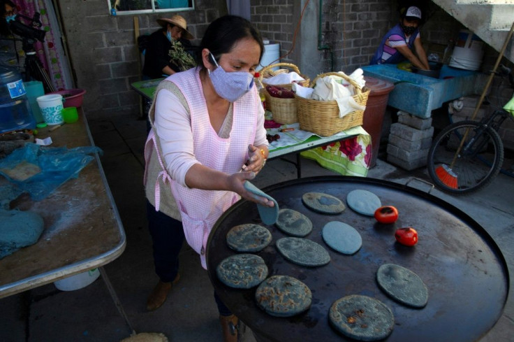 A member of the group Women of the Earth makes tortillas in a kitchen on the edge of Mexico City