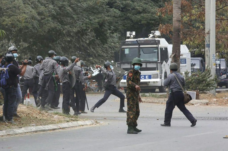 Police throw projectiles towards protesters during the Mandalay disturbance