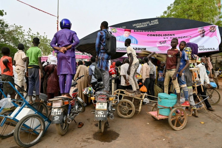 Supporters stand on their motorcycles to get a better view at a Bazoum campaign rally