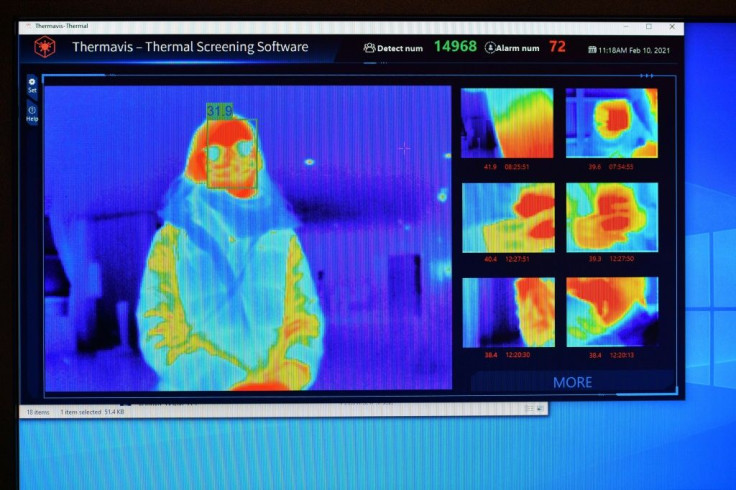 A thermal imaging camera are displayed on a screen as a person waits at the reception desk at the St Giles Hotel near Heathrow Airport in west London, in an example of technology being used to screen for Covid-19 symptoms