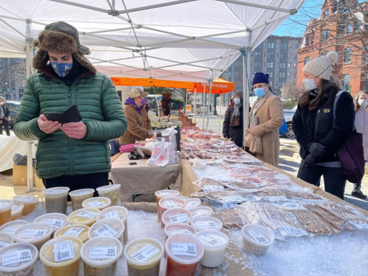 Shoppers wearing face masks keep their distance from one another at the Dupont Circle Market in Washington