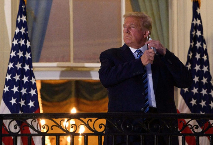 Then-US President Donald Trump takes off his facemask on October 5, 2020 as he arrives at the White House upon his return from Walter Reed Medical Center, where he underwent treatment for Covid-19, in Washington, DC