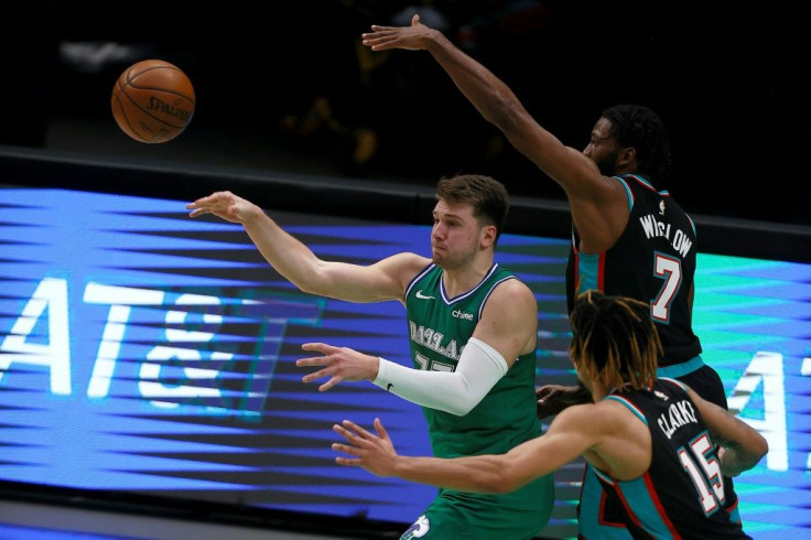 Dallas Mavericks star Luka Doncic passes the ball against Brandon Clarke, 15, and Justise Winslow ,7, of the Memphis Grizzlies in the second half at American Airlines Center