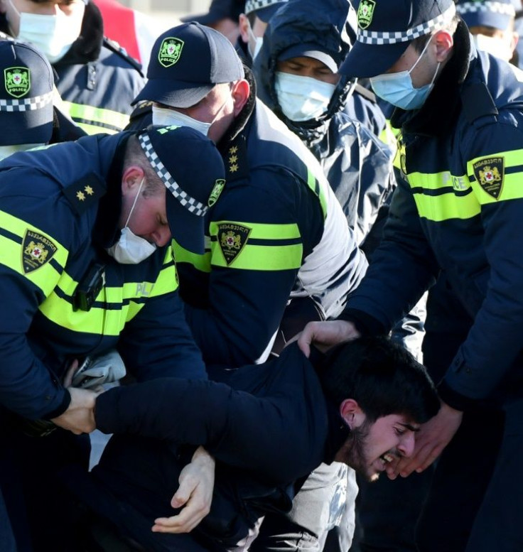 Georgian police detain an opposition supporter during the rally