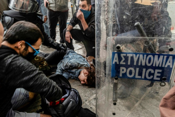 Demonstrators and police gather around 25-year-old protester Anastasia Demetriadou after she was hit by water cannon during a protest in Cyprus' capital this month