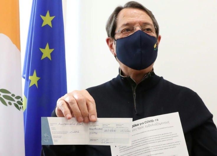 Cypriot President Nicos Anastasiades displays his Covid-19 vaccine certificate at a health centre in Nicosia in December