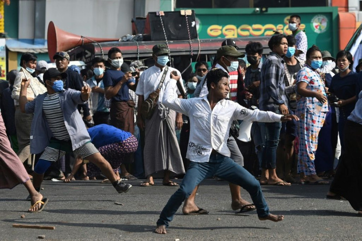 Supporters of Myanmar's military throw objects at residents in Yangon on Thursday