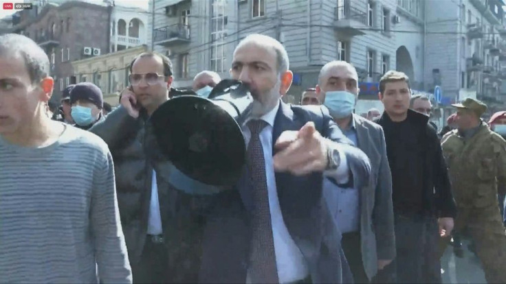 Armenian Prime Minister Nikol Pashinyan marches through the streets of the capital Yerevan with his supporters after accusing the military of mounting an attempted coup.