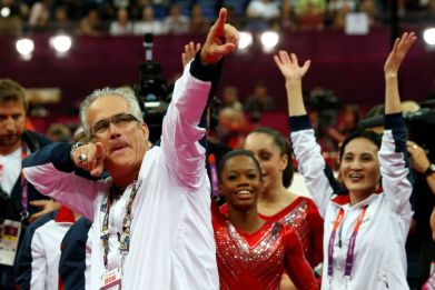 Former US women gymnastics team's coach John Geddert, seen here celebrating a London Olympics gold medal with US team members, has been charged with human trafficking and criminal sexual conduct by prosecutors in Michigan
