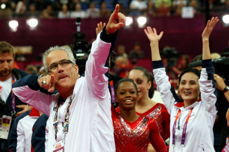 Former US women gymnastics team's coach John Geddert, seen here celebrating a London Olympics gold medal with US team members, has been charged with human trafficking and criminal sexual conduct by prosecutors in Michigan