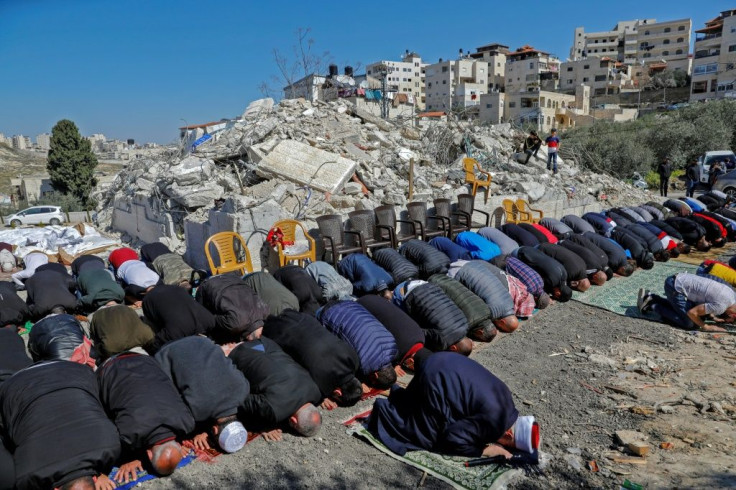 Palestinian Muslim worshippers attend Friday noon prayers in front of the rubble of buildings demolished by Jerusalem municipality workers, reportedly built without an Israeli construction permit, in the mostly-Arab East Jerusalem neighbourhood of Issawiy