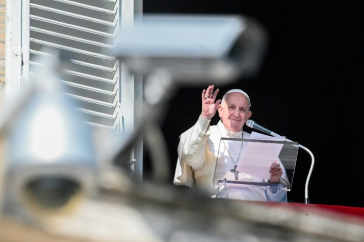 Pope Francis waves from the window of the apostolic palace overlooking St. Peter's Square on February 21, 2021; security cameras are seen in the foreground