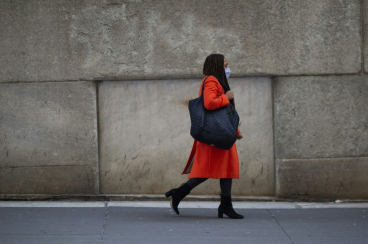 A woman walks near Wall Street, where prestigious professions and those that pay the most, like investment bankers and traders, still remain strongholds of white men