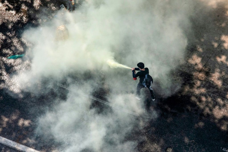 A protester uses a fire extinguisher as security forces crack down on demonstrations against the military coup in Yangon