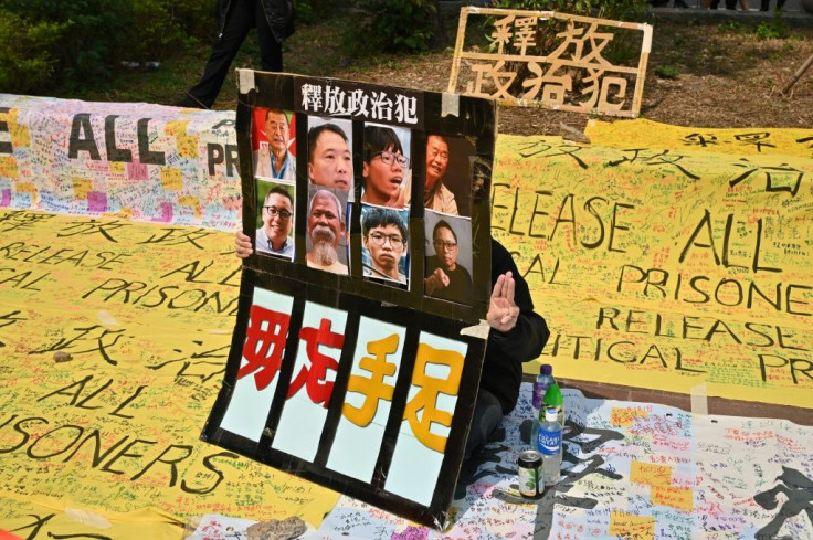 A pro-democracy supporter displays a placard outside the West Kowloon court in Hong Kong as dozens of dissidents are charged with subversion