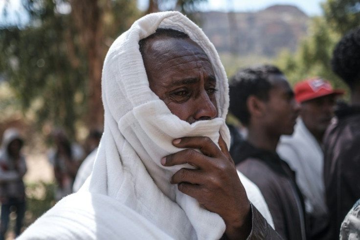 Men in Dengolat covered their faces to weep as women pounded the ground and showed images of their loved ones