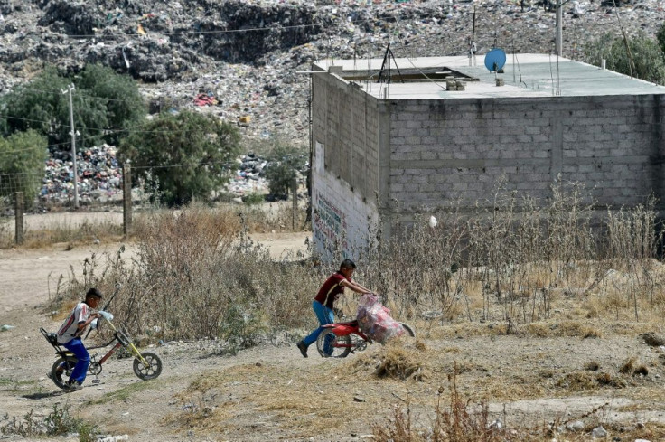 Some children from the neighborhood help their parents scavenging for trash that can be recycled