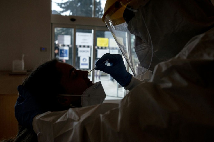 A Czech soldier wearing protective equipment (PPE) takes a sample from a patient at a coronavirus testing centre in Chodova Plana town, western Bohemia