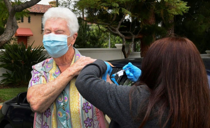 Nurse Liliana Ocampo administers the Moderna Covid-19 vaccine into the arm of Sister Pat Foster in Los Angeles