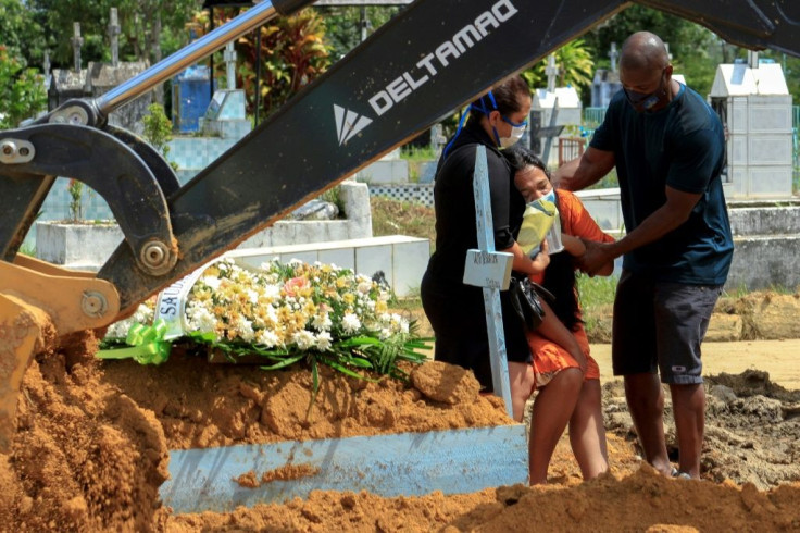 In this file photo taken on January 22, 2021 relatives of a Covid-19 victim mourn during a funeral at the Nossa Senhora Aparecida cemetery in Manaus,  Brazil