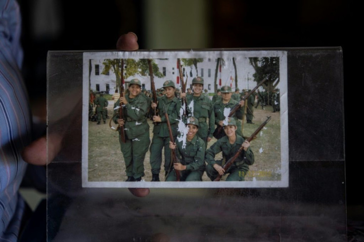 Ismaira Figueroa, a sniper for the Bolivarian militia, shows a picture of her (2R top) posing with comrades after their graduation, during an interview with AFP at her house in Baruta neighbourhood in Caracas