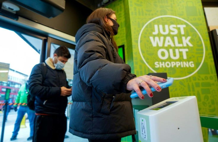 A customer scans her phone containing a special code as she enters the store that lets it know who she is in order to charge her for the goods she takes