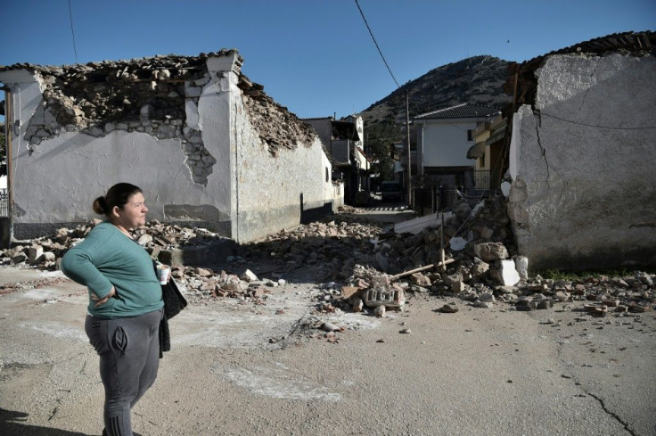 A woman stands by damaged old buildings in the village of Damasi, near the town of Tyrnavos, after a strong 6.3-magnitude earthquake hit the Greek central region of Thessaly on March 3, 2021