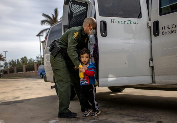 A US border agent transports a child who is seeking asylum to a bus station in Brownsville, Texas, on February 26, 2021