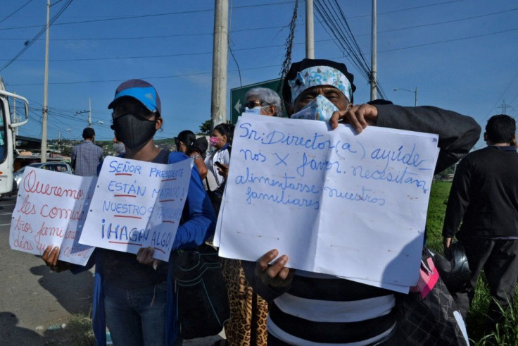 Relatives of inmates protest with signs outside the prison in Guayaquil, Ecuador, on February 25, 2021, after  riots in which at least 79 prisoners died