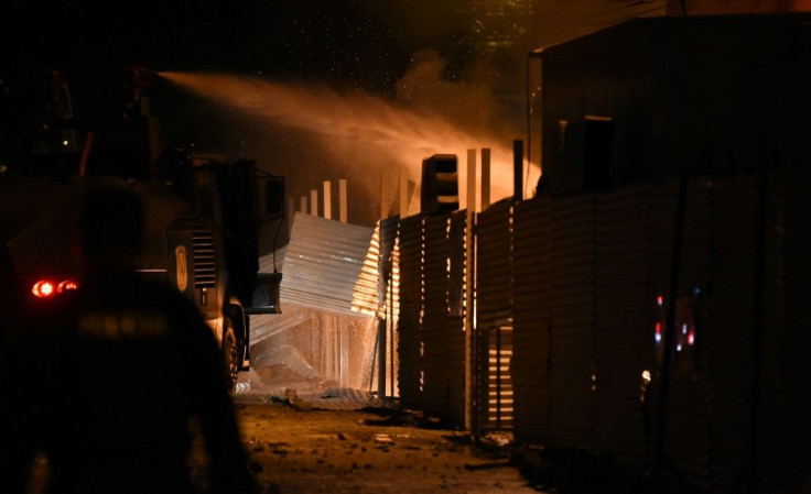 A police water cannon tries to put out a fire set by protestors at the commerce ministry headquarters in Asuncion