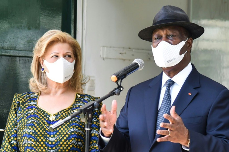 President Ouattara, with his wife Dominique, speaks to reporters after casting his vote