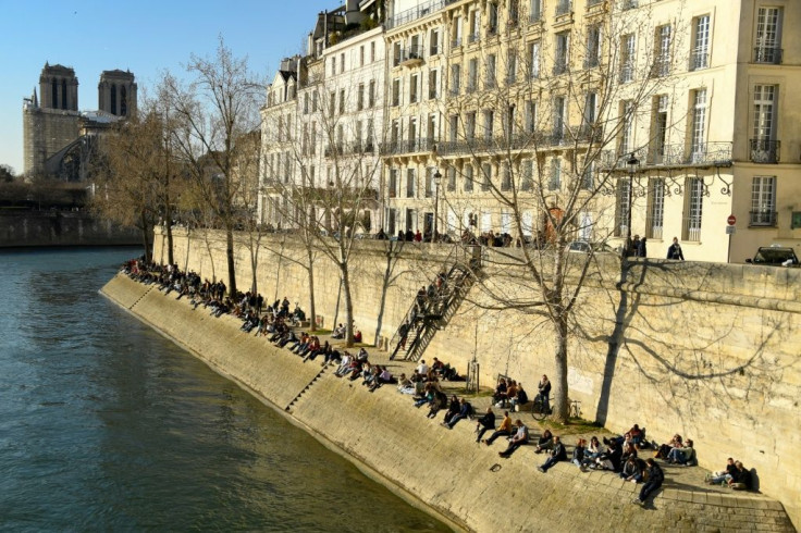 Paris police cleared people from the banks of the Seine as Parisians, drawn by the sunshine, ignored social distancing guidelines