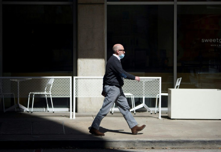 A man with a mask walks through downtown Houston, Texas on March 3, 2021