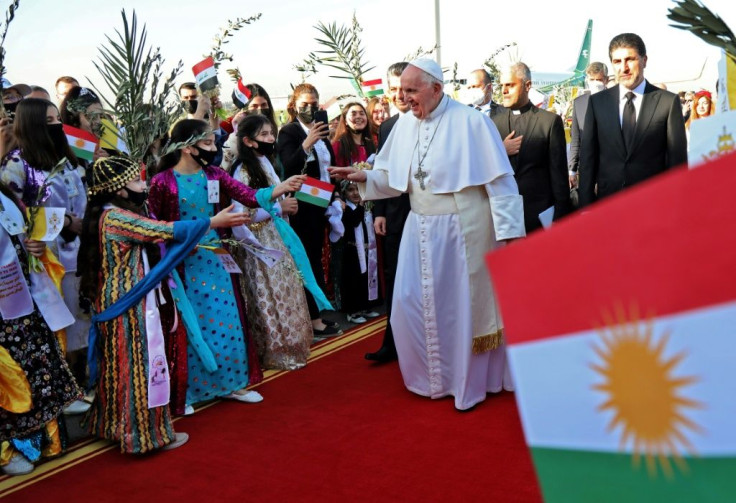Pope Francis greets Iraqis dressed in traditional outfits upon his arrival at Arbil airport in Kurdish Iraq on Sunday