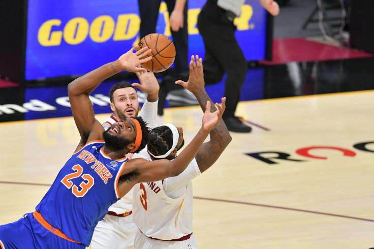 Mitchell Robinson #23 of the New York Knicks fights for a rebound over Andre Drummond #3 and Larry Nance Jr. #22 of the Cleveland Cavaliers