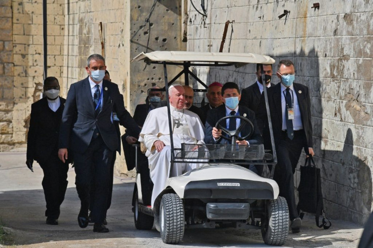 Pope Francis rides in a golf cart in the old city of Iraq's northern Mosul