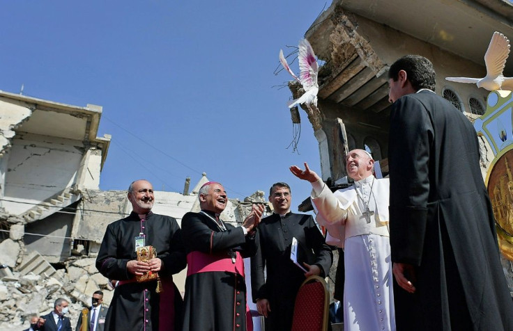 Pope Francis releases a white dove near the ruins of the Syriac Catholic Church of the Immaculate Conception, in the Iraqi city of Mosul on Sunday