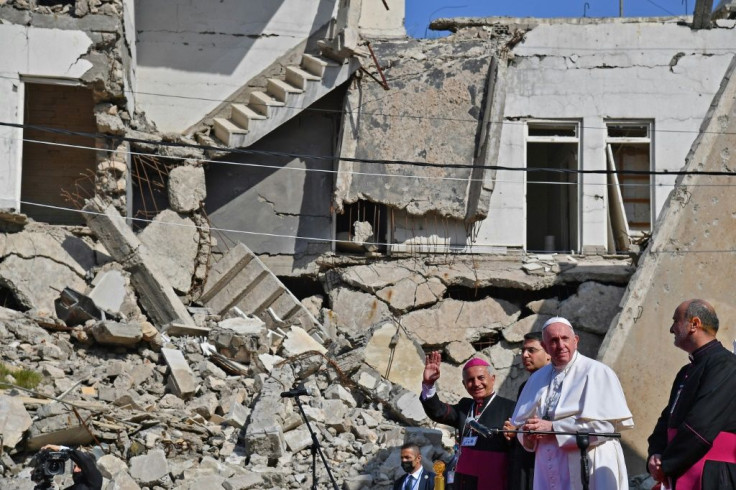 Pope Francis, accompanied by the Chaldean Catholic Archbishop of Mosul Najib Michaeel Moussa, near the ruins of the Syriac Catholic Church of the Immaculate Conception in the old city of Iraq's Mosul