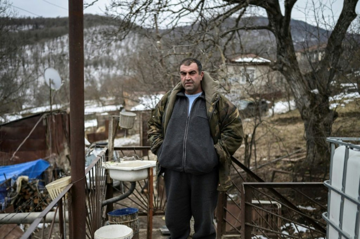 Khachik Stepanyan outside the houses he and his family are staying in, which is only a few meters away from the home they were forced to abandon