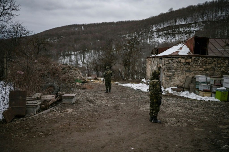 Armenian soldiers stand guard outside houses in Shurnukh village. Up until a few months ago the nearest Azerbaijani presence was dozens of kilometres away