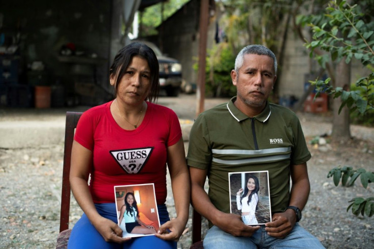 Mileidys Torrealba (L) and Eduard Jose Falcon display pictures of their murdered daughter Eduarlis Falcon
